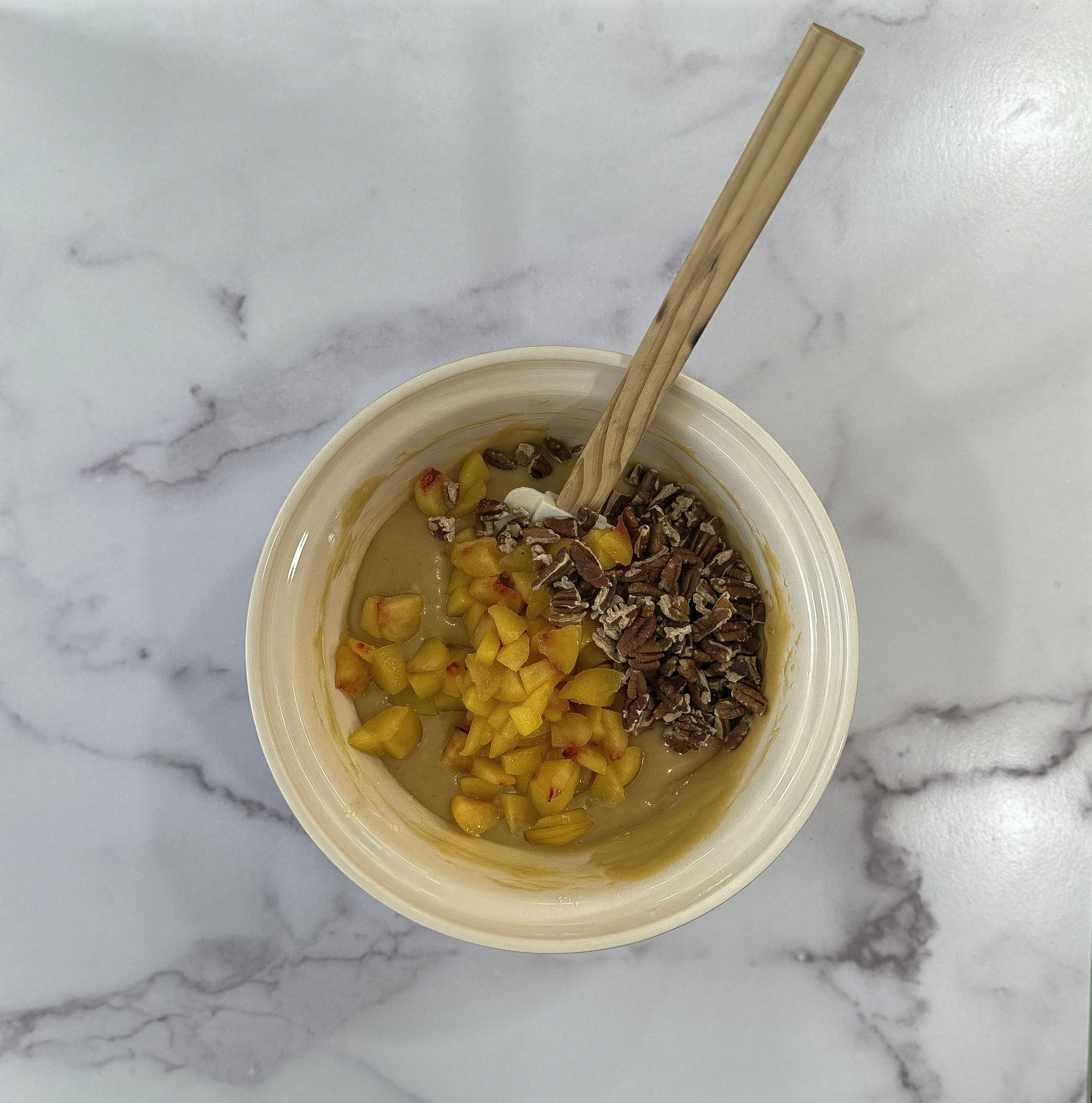 Chopped fresh peaches and roasted pecans are ready to be folded into the rich peach yogurt batter.